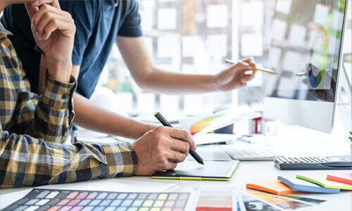 The hands of multiple workers at a desk